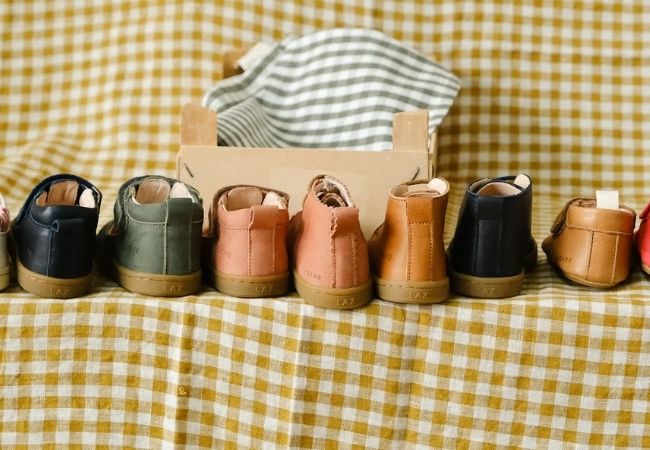 Alignement de chaussures et chaussons en cuir souple sur une nappe vichy jaune