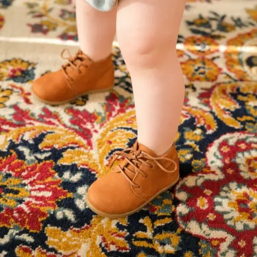 enfant debout portant des chaussures lou caramel